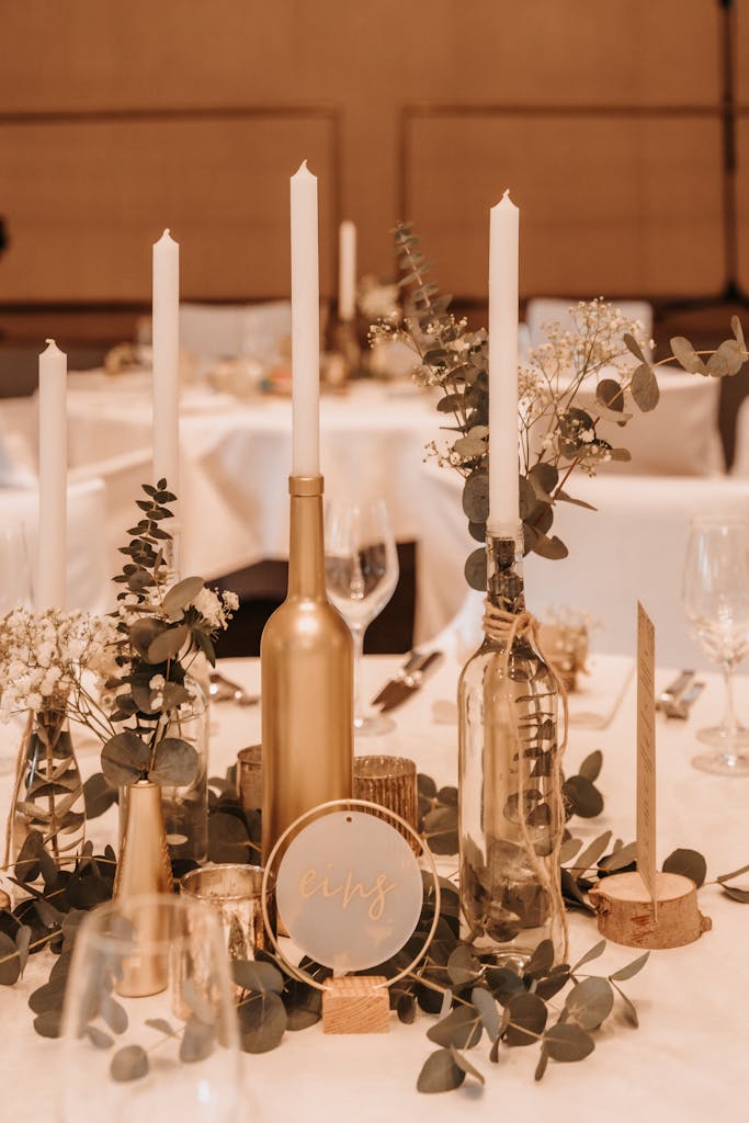 Stylish wedding table centerpiece featuring candles, eucalyptus, and gold accents for a chic decor.